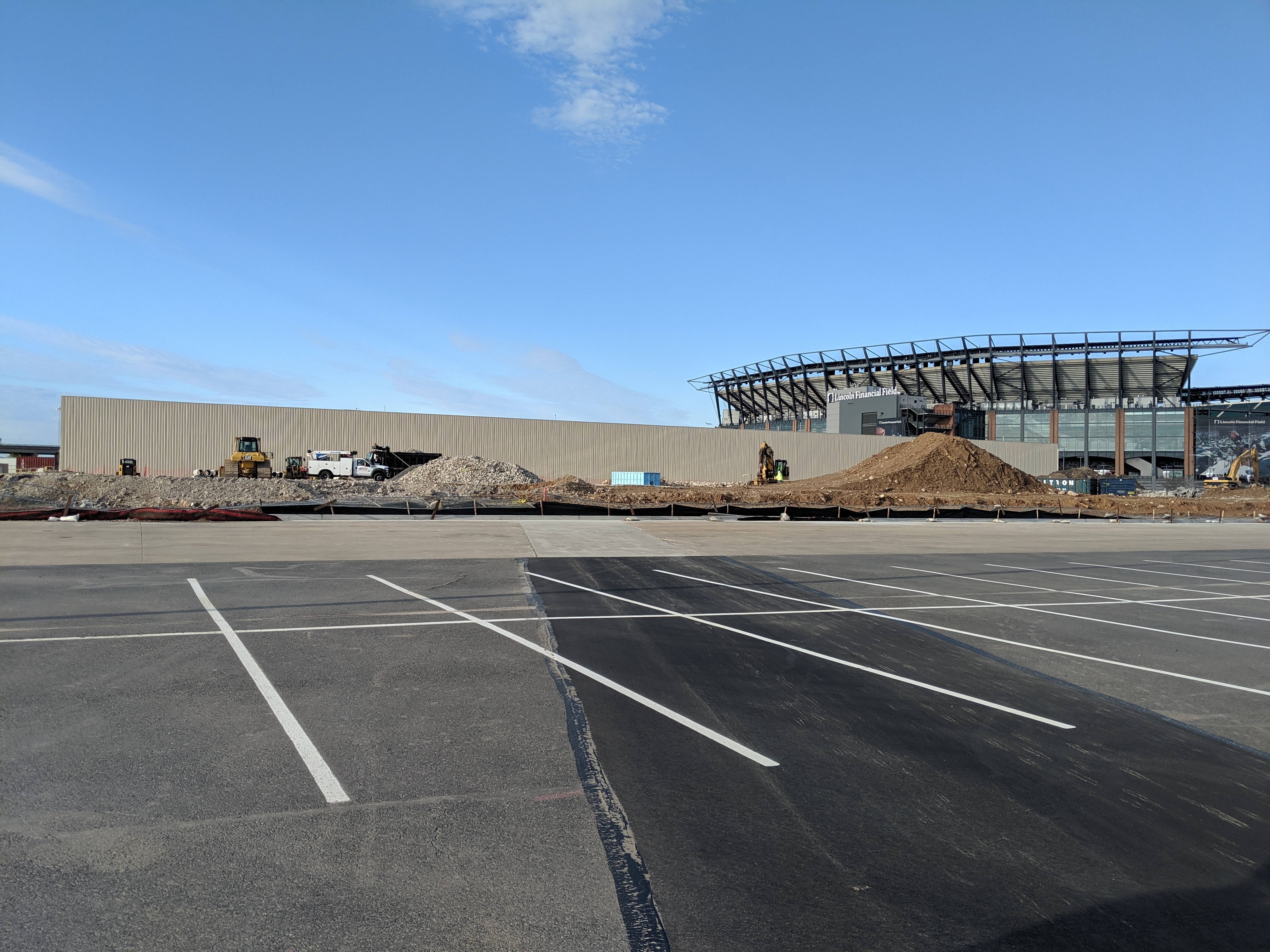 Stadium-district parking lot in South Philadelphia built above the Darien Crossing stormwater detention basin, with Lincoln Financial Field in the background